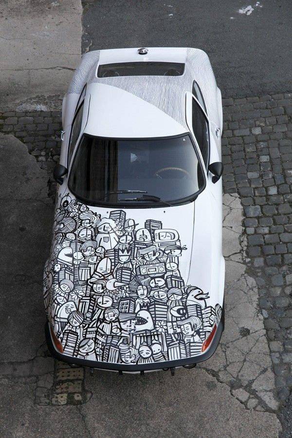 A top view of a car with black and white graffiti car wrap