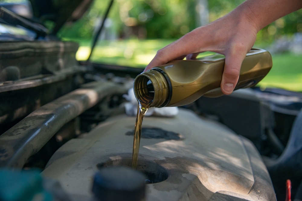 A view of a person oil to the car engine