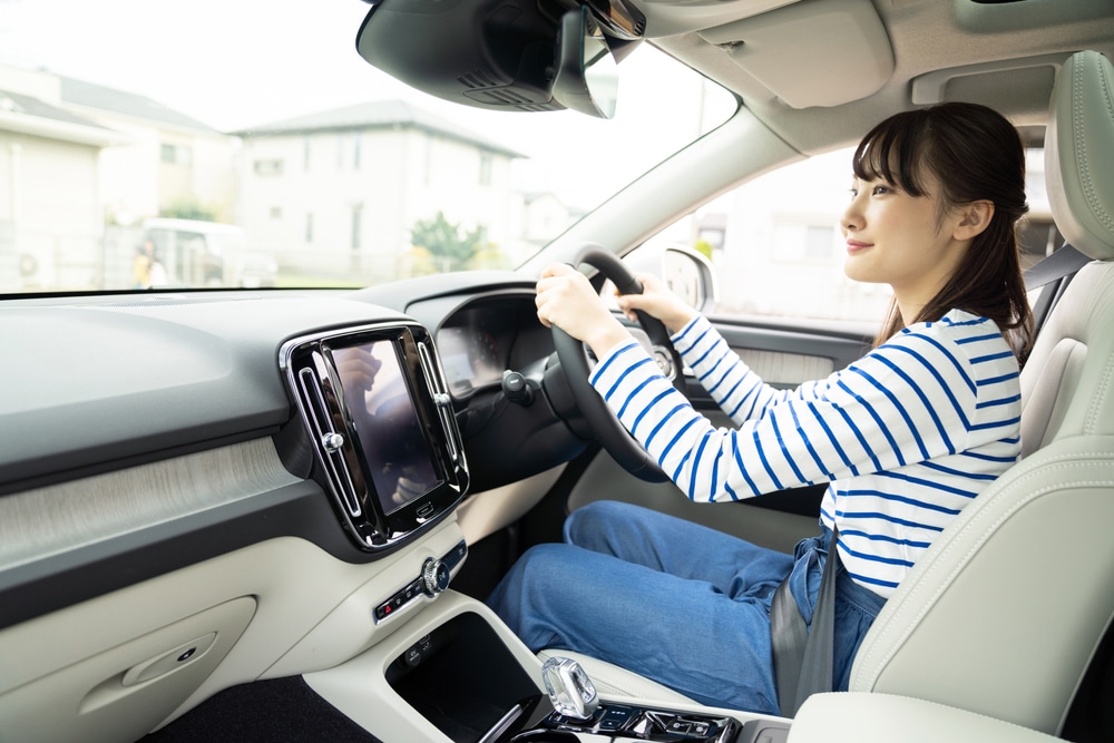 A view of an asian girl driving car