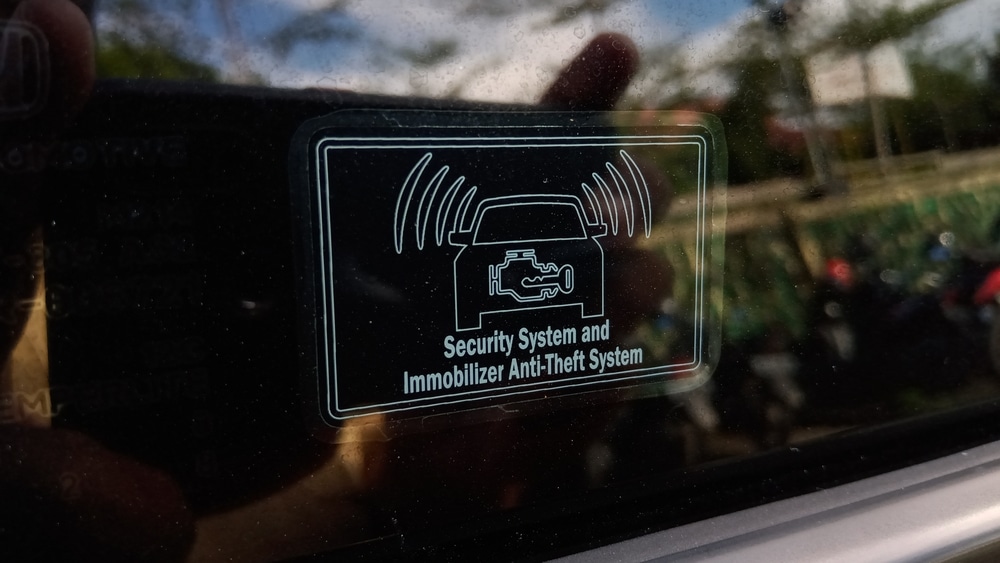 A view of a car alarm system sticker over a car window