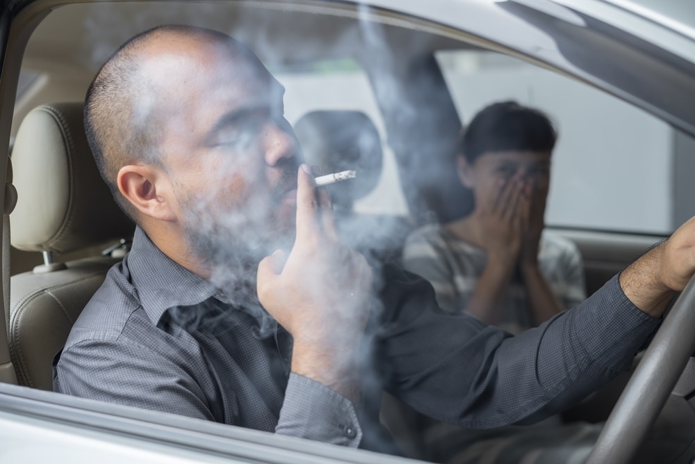 A view of a person smoking inside car