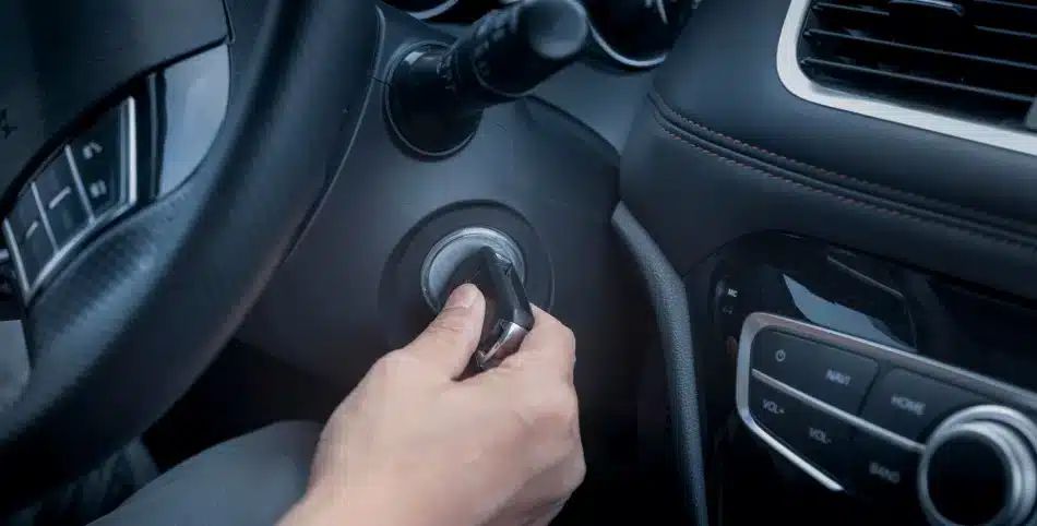 a man holding the car key in his hand to start a car