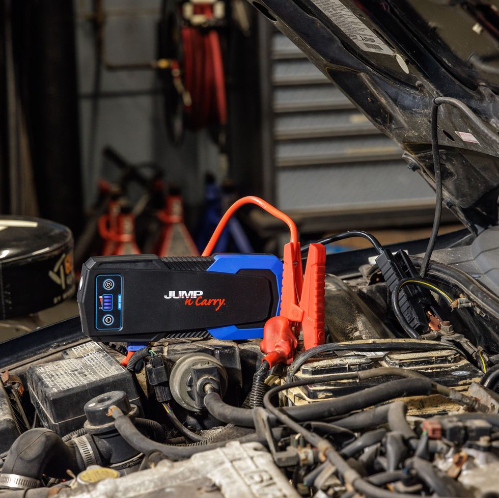 a portable jump starter attached to the battery in a car