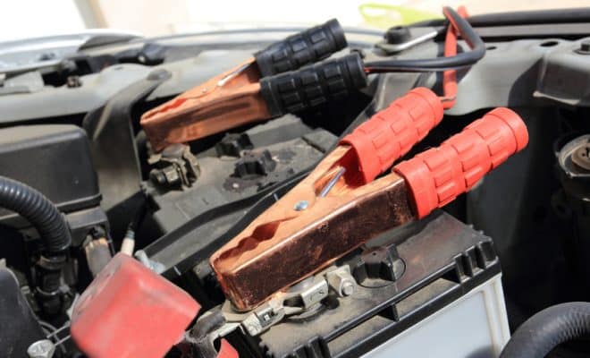 jumper cables connected to the terminals of a car battery