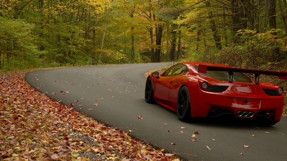 A back view of a red sports car racing on a road