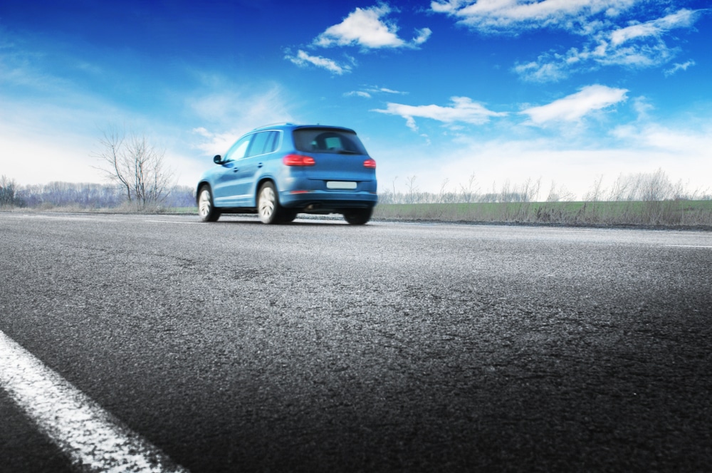 A backview of a blue crossover car on road