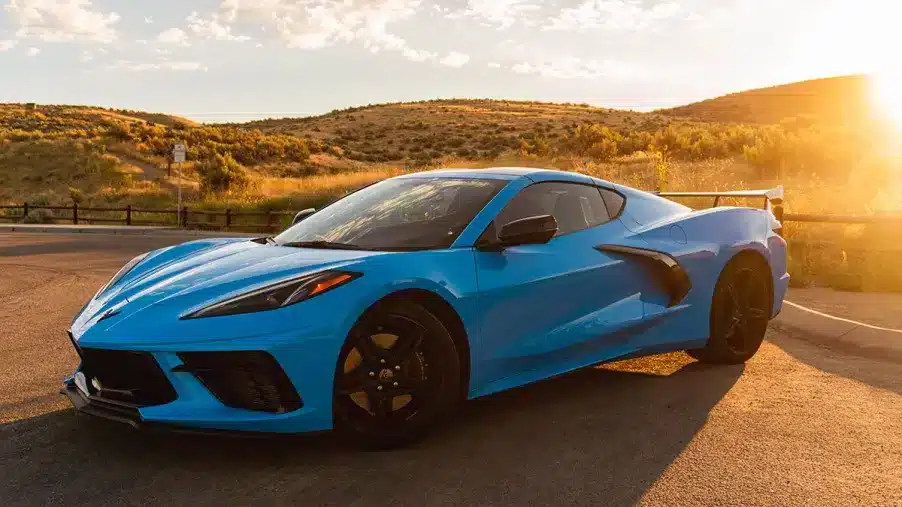 A view of a blue sports car with a sunsetting view