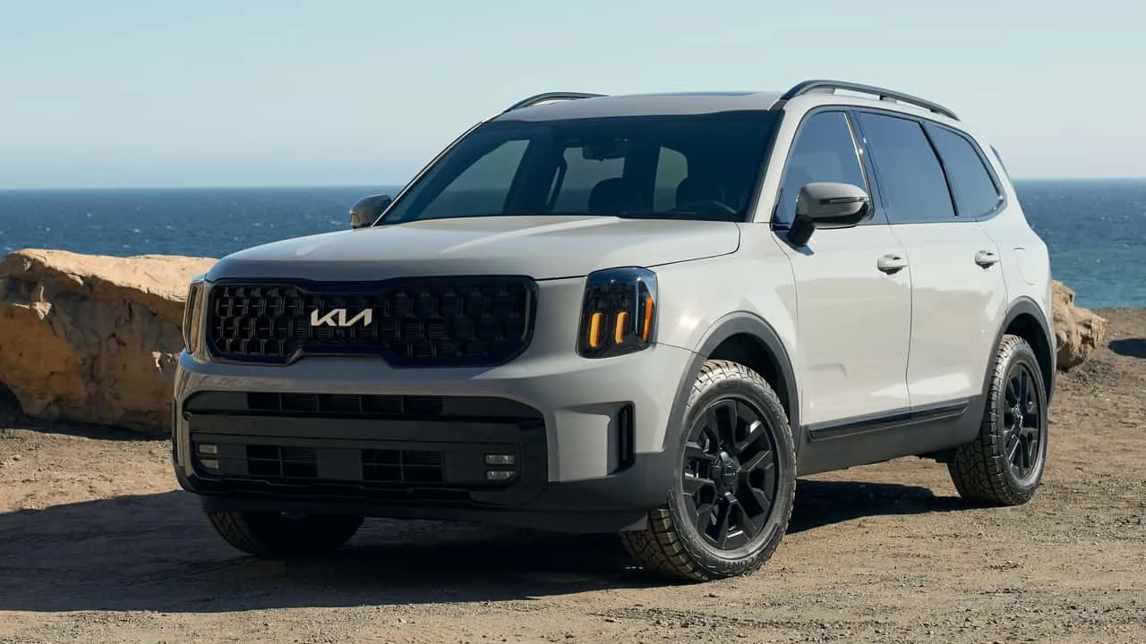 A view of a grey kia telluride parked by a beachside