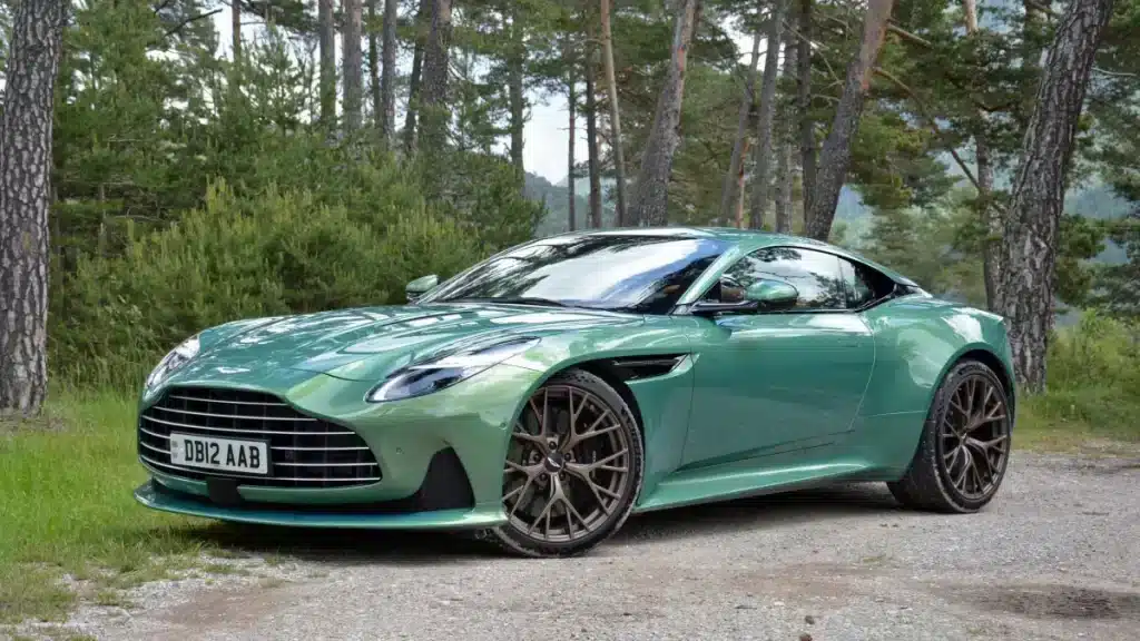 A view of a mint green aston martin db parked in a forest