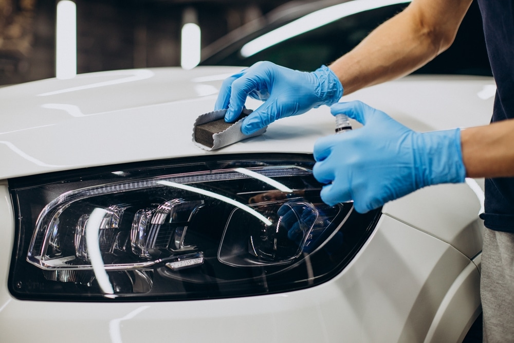 A view of a person applying ceramic coating on a car surface