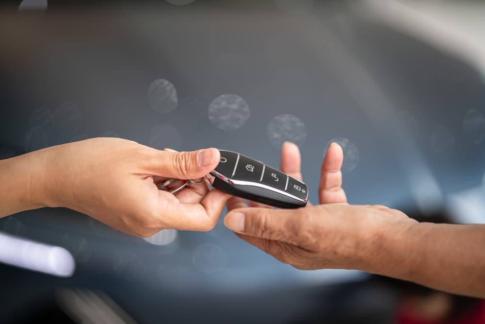 A view of a person giving car keys to another person