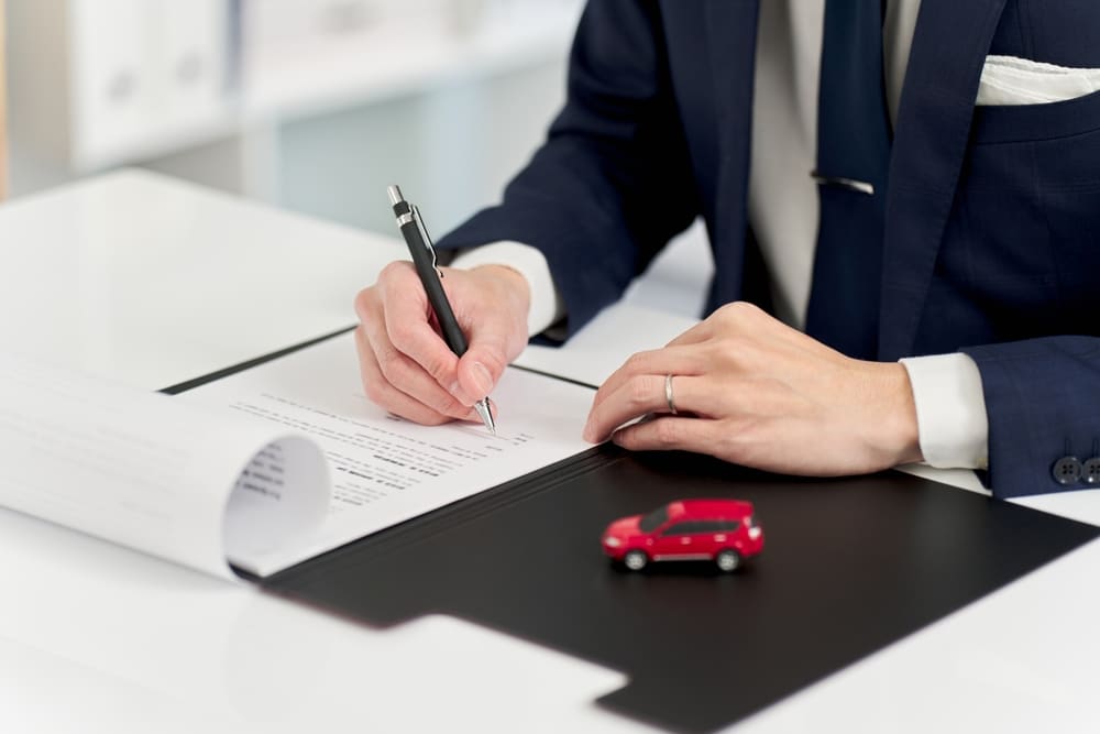 A view of a person signing off car lien