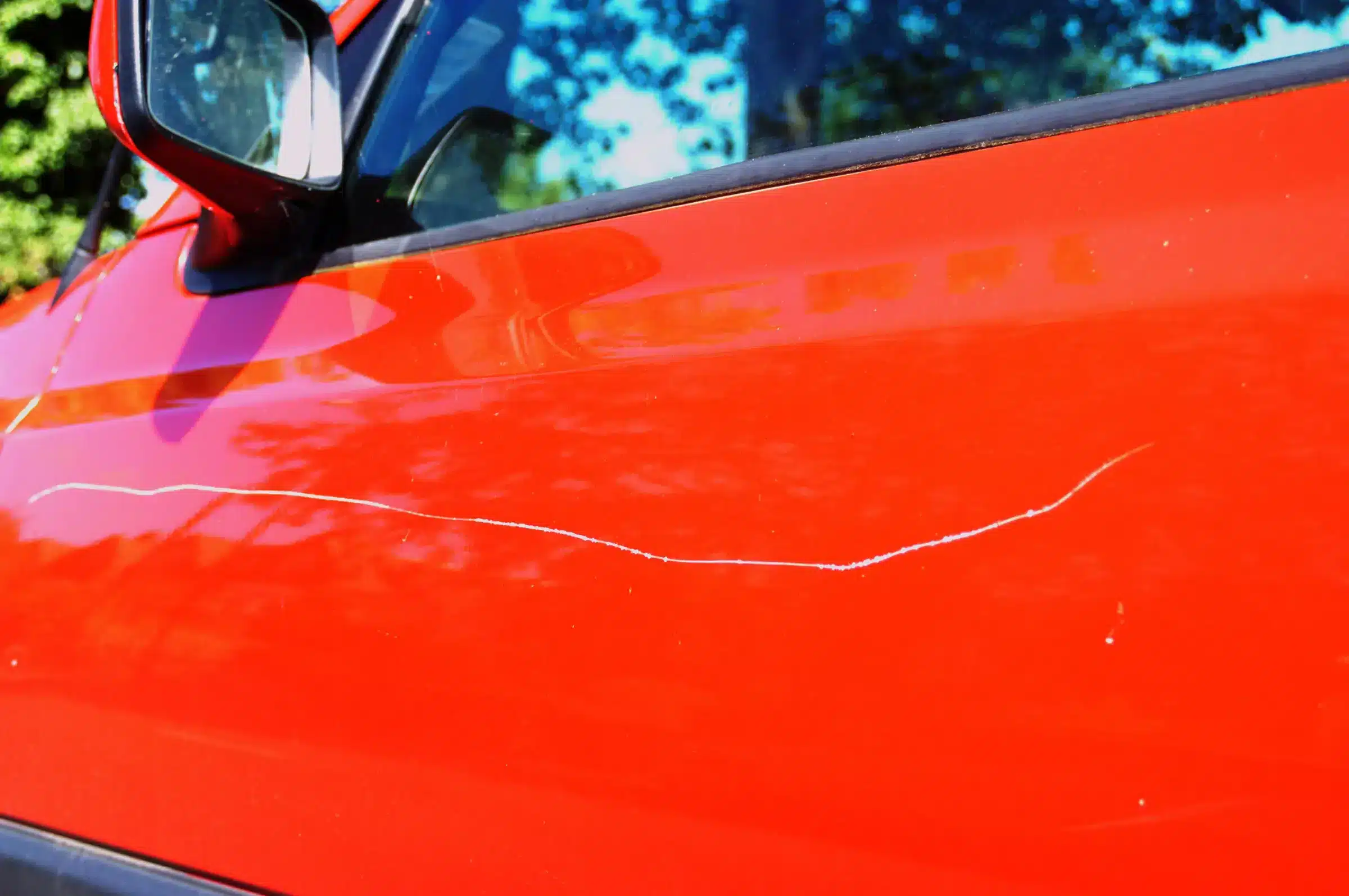 A view of a scratch on a red car