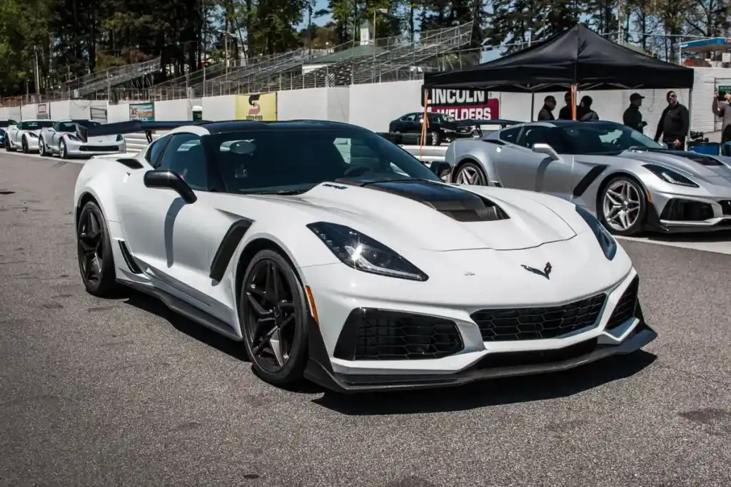 A view of a white chevrolet corvette parked at a racing pit stop