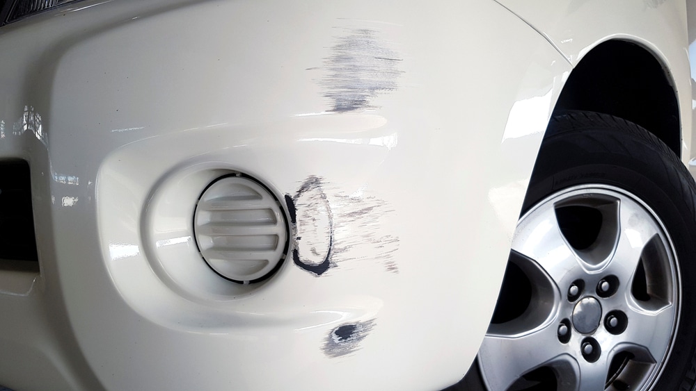 A view of a white car with scratches