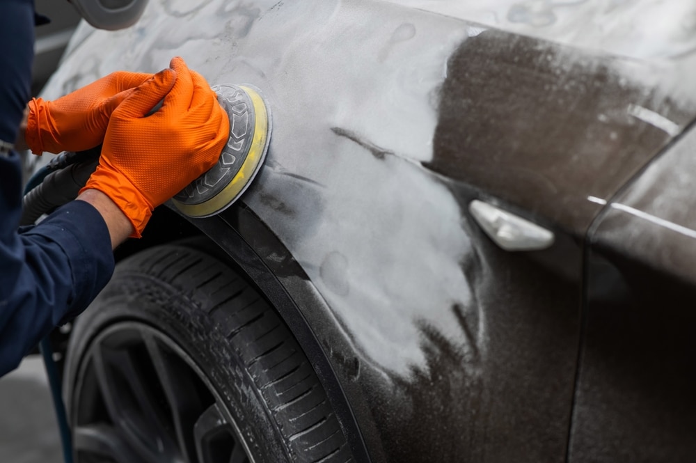 A view of a person applying putty on a car's exterior