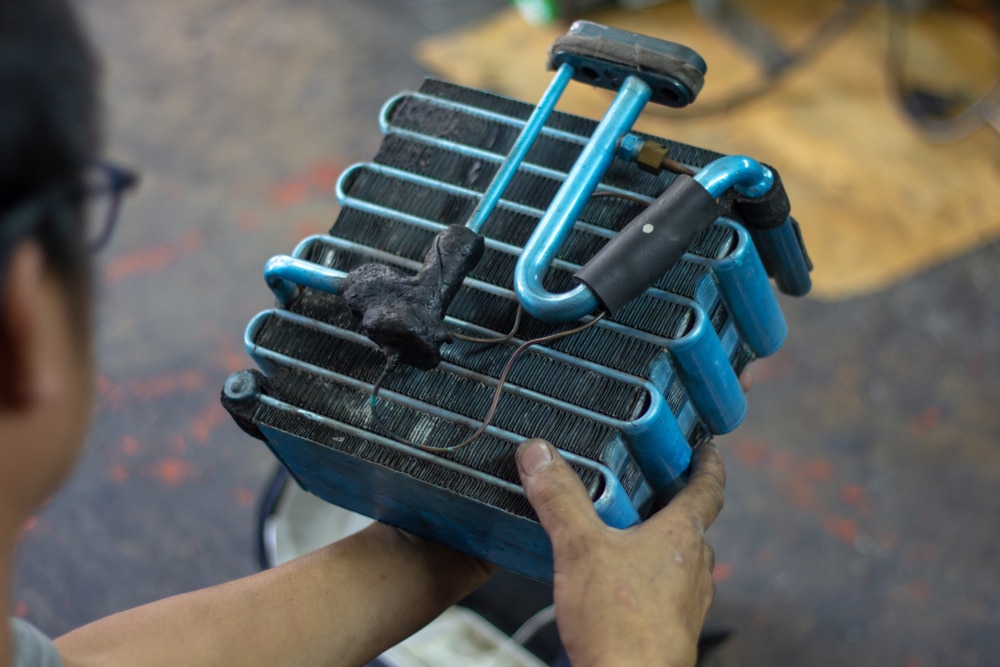 A view of a person holding a car ac evaporator