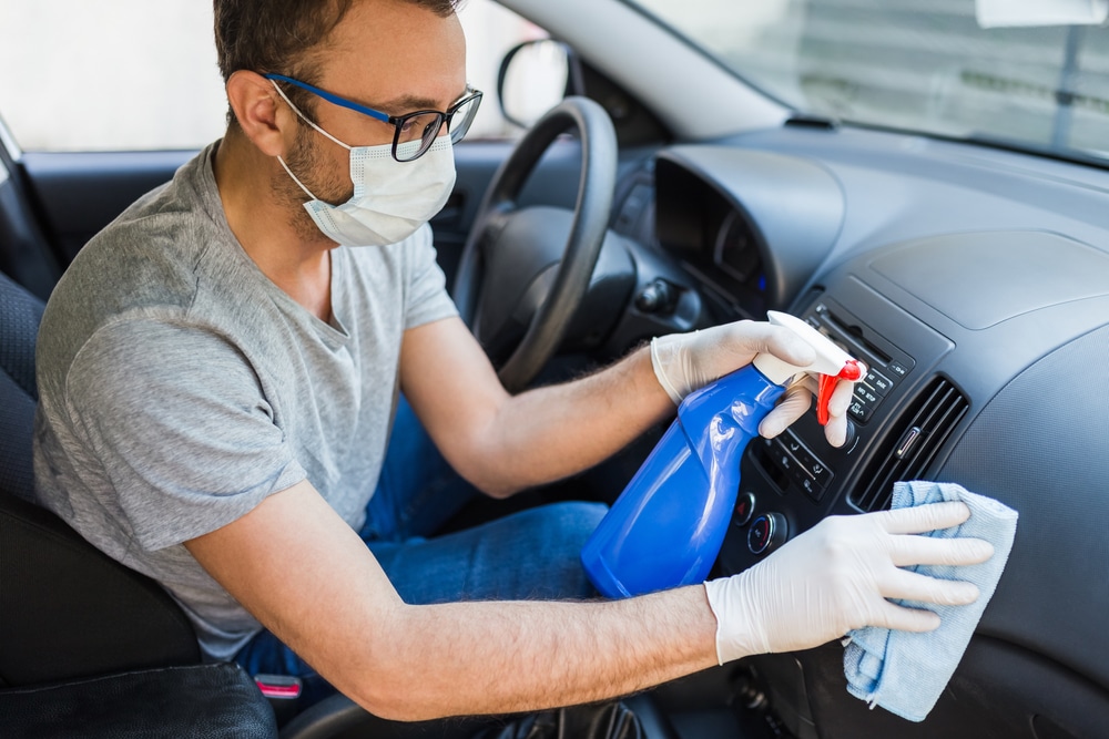 A view of a person cleaning a car dashboard