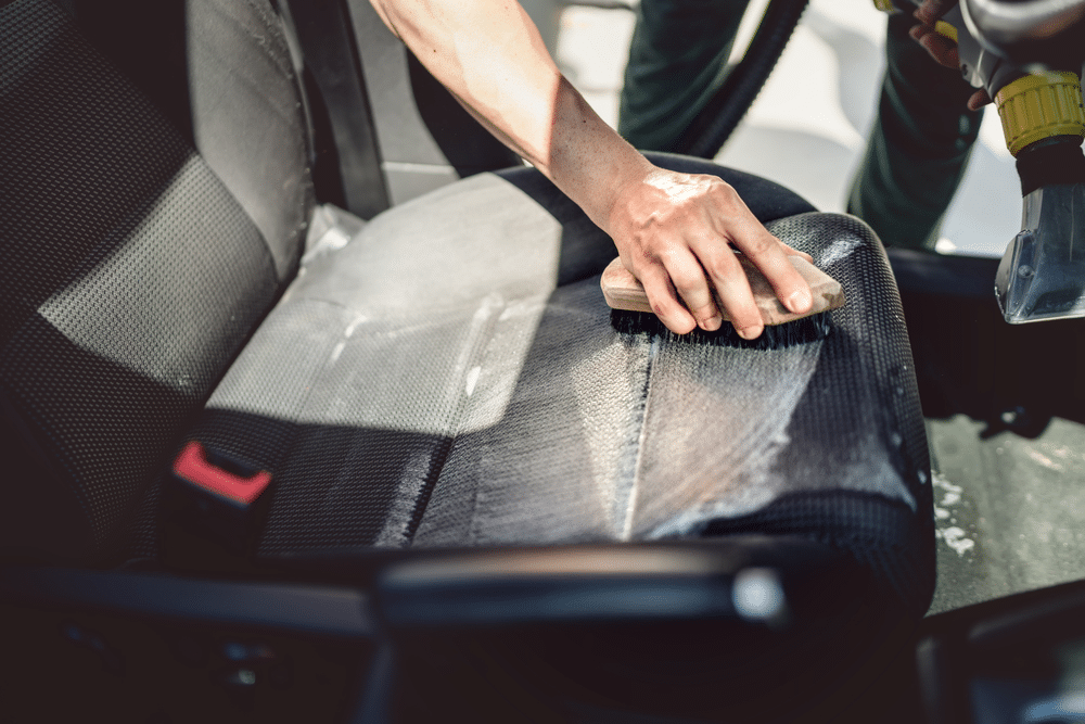 A view of a person cleaning leather car seats